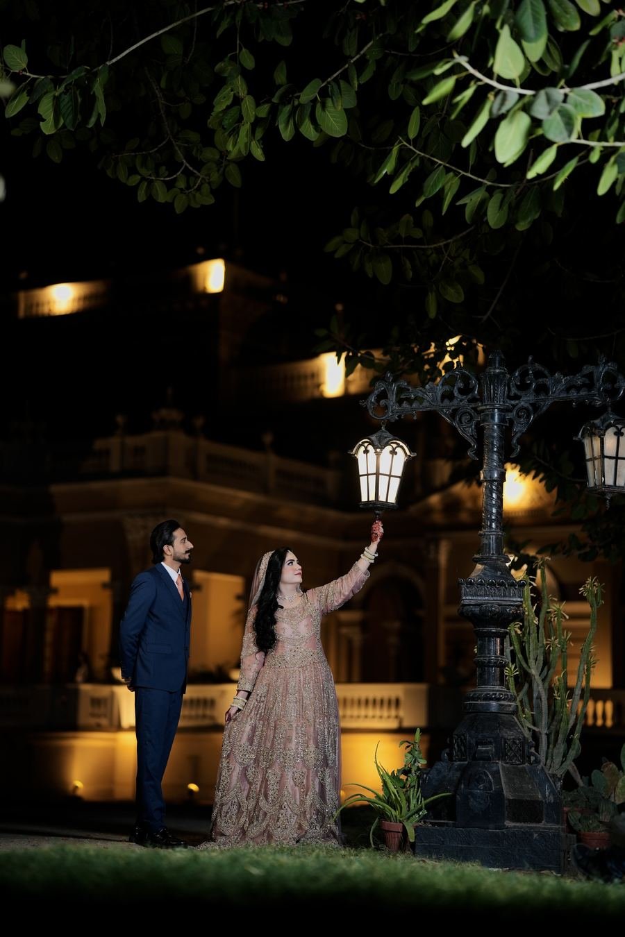Couple under a lamp post in a palace garden at night